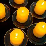 Significado de las velas naranjas, varias velas naranja encima de platos negros