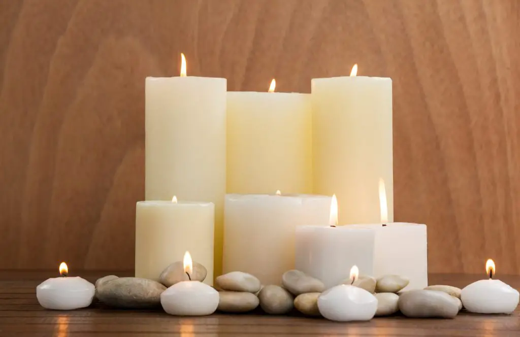Significado de velas blancas, velas con piedras en un fondo de madera