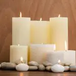 Significado de velas blancas, velas con piedras en un fondo de madera